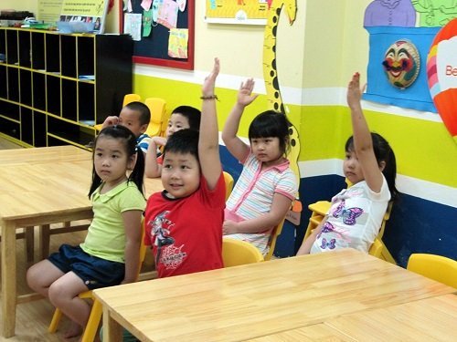 Các bé tập trung giơ tay phát biểu trong giờ học