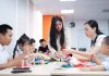 Bàn workshop đông vui với phụ huynh và các bé đang chăm chú dán giấy lồng đèn truyền thống.