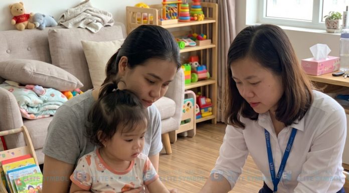 Chuyên viên của sinh trắc vân tay Elite Symbol đang lấy mẫu sinh trắc vân tay tại nhà bằng thiết bị quét 1 ngón trỏ cho em bé